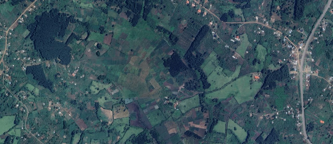 Aerial view of the Rwenzori highlands showing farmland divided into many small, irregular plots interspersed with scattered homesteads